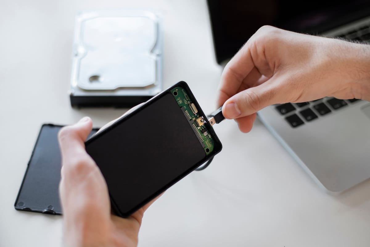 A man backing up files to an external storage drive