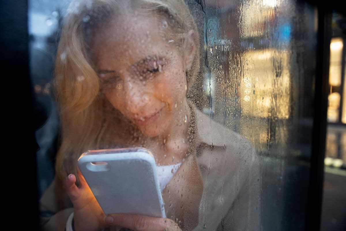 A woman using her smartphone in the rain